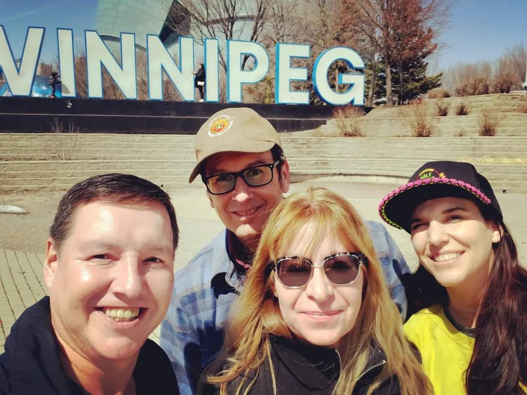 FB_IMG_1651627410053 Interindigital Entertainment Inc. media company standing in front of the Winnipeg sign.