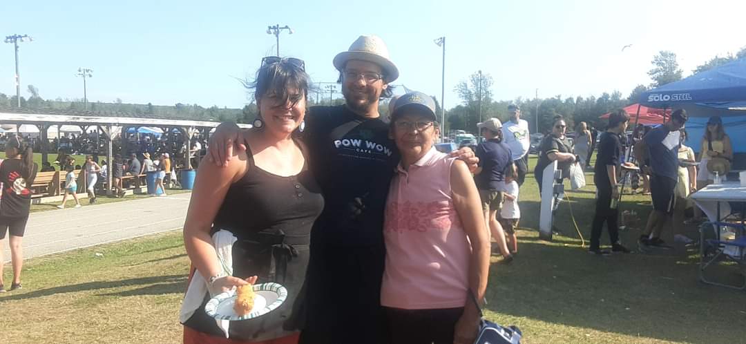 FB_IMG_1659611645681 A small group of people posing for a picture at a food festival.